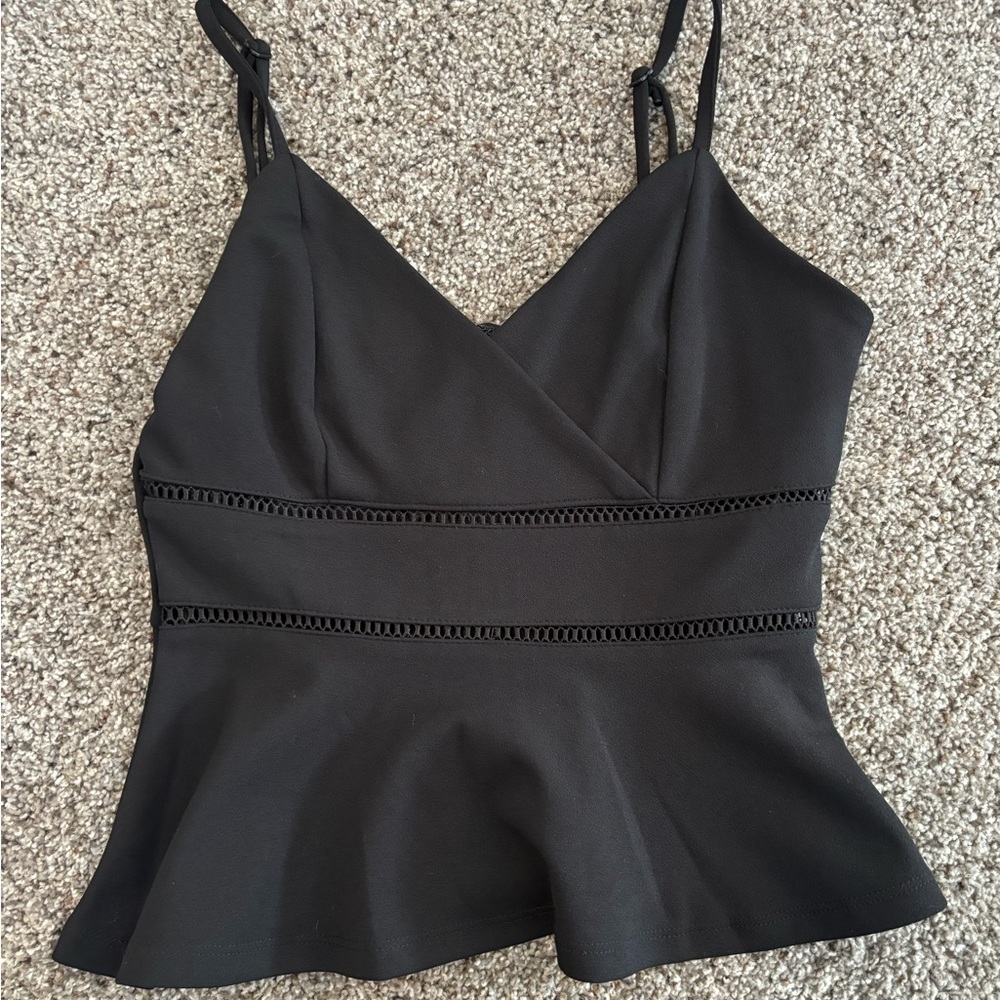 Black dress top with details along the front and ruffled bottom.